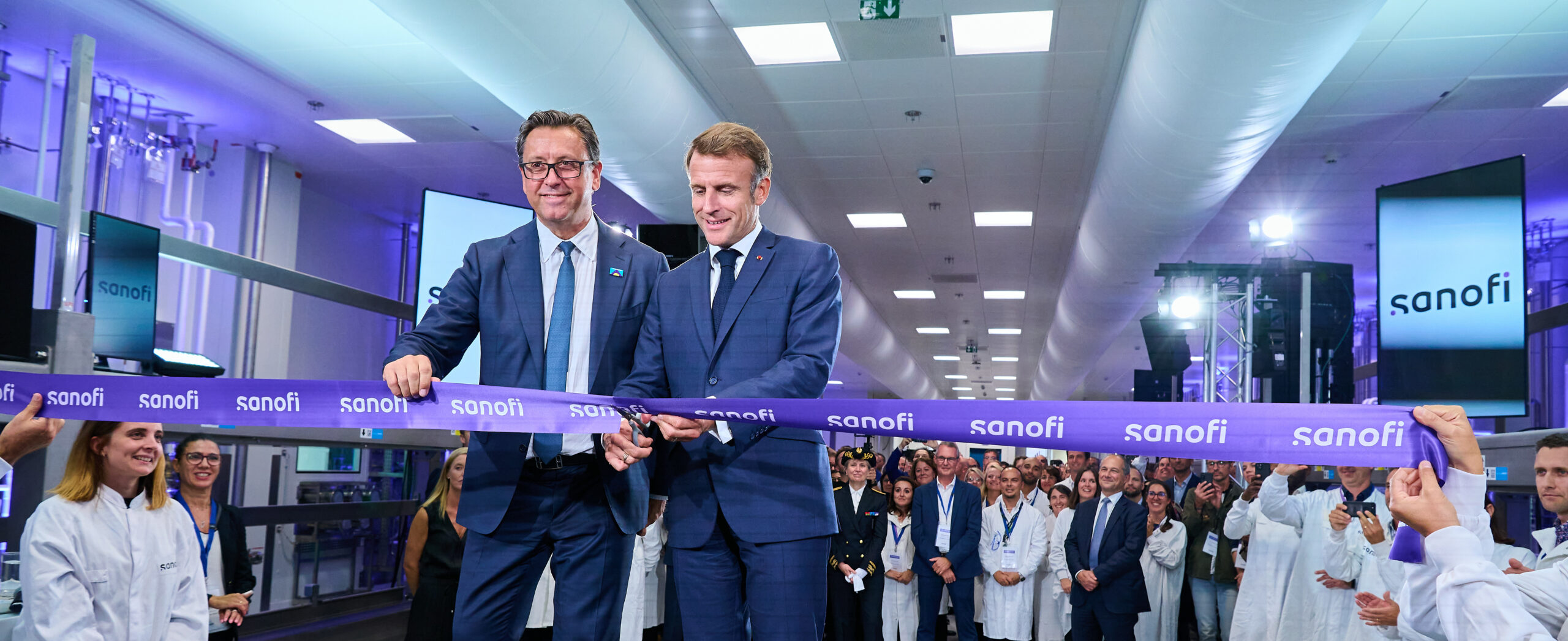 Emmanuel Macron et un représentant de Sanofi inaugurent l'usine Modulus lors de la cérémonie d'ouverture officielle, entourés de l'équipe Sanofi.